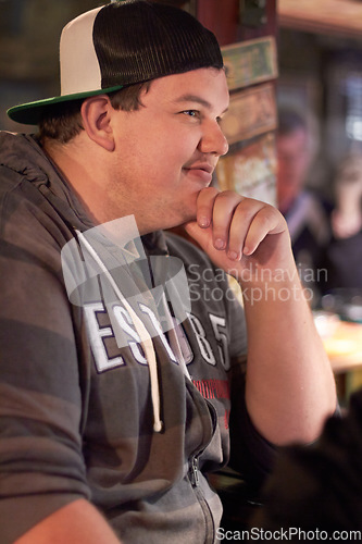 Image of Man in pub, relax and thinking with reflection on life and ideas, future and dream. Contemplating, decision or choice with plus size person in bar for social gathering, leisure and enjoy with smile