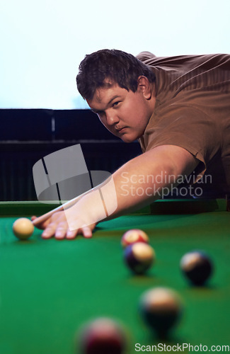 Image of Man playing pool, game and aim with cue and ball, social event at sports bar or restaurant for contest. Competition, focus and serious player, billiard or snooker with concentration for target in pub