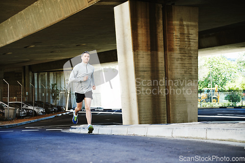 Image of Man, runner and fitness on road in outdoor, cardio and exercise or training for marathon. Male person, athlete and workout by city background, sportswear and performance challenge by bridge on street