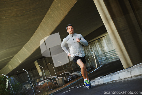 Image of Man, runner and exercise on road in outdoor, cardio and fitness or training for marathon. Male person, athlete and workout by city background, sportswear and performance challenge by bridge on street