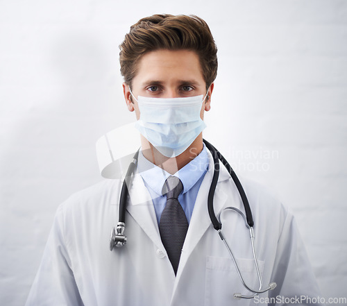 Image of Man, portrait and doctor with face mask for protection, health and safety on mockup space. Male person, surgeon or medical professional with stethoscope for healthcare on a white studio background