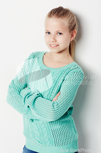Image of Child, portrait and fashion pride in studio, cool and confidence by white background. Female person, girl and casual clothing or style by backdrop, kid and trendy winter sweater or smiling face