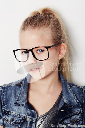 Image of Child, portrait and cool fashion glasses in studio, frame and confident by white background. Female person, girl and casual clothing or style by backdrop, kid and denim jacket pride for eyesight test