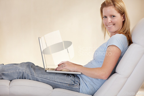 Image of Woman, remote work from home and laptop on chair, portrait and type email for job, copywriter or creative. Freelancer, technology and working for startup publishing company, internet and online