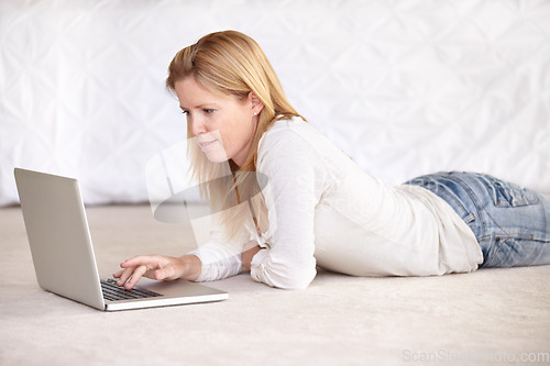 Image of Woman, work from home and laptop on floor, smiling and type email for job, copywriter or creative. Freelancer, technology and working for startup publishing company, internet and online worker