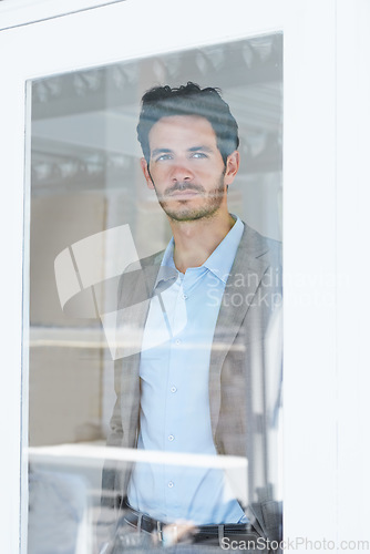 Image of Man, serious by window and thinking of business ideas, brainstorming or reflection with insight and inspiration. Corporate professional, mission with decision and future in company with planning