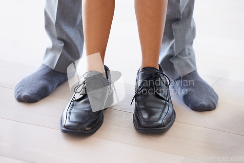 Image of Feet, man and child wearing shoes with dad, getting ready and morning with legs, closeup and socks. Standing, house and childhood for fun, young and bonding together with parent, home and playing