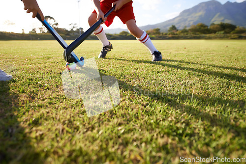 Image of Children, ball and playing hockey on field for game, sports or outdoor match together. Team, kids or players in competition on green grass for tackle, practice or training in fitness or nature