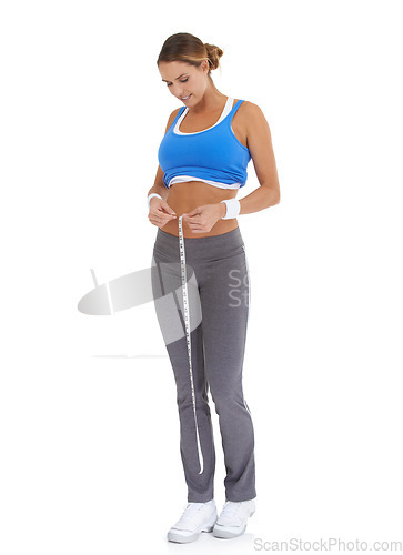 Image of Woman, stomach and measure tape in studio for diet, weight loss and health results or fitness progress. Sports person smile and check body in exercise, workout or training goals on a white background