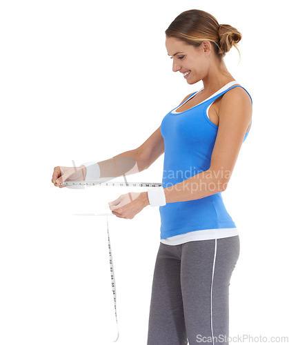 Image of Woman, stomach and measure tape in studio for fitness, weight loss or health results with training progress. Happy model or person check her waist for exercise or workout goals on a white background