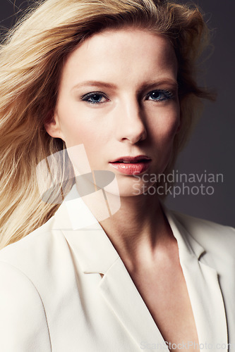 Image of Woman, face and beauty, makeup or cosmetics for wellness with confident, serious model on isolated dark background. Pride, ambition and power in portrait, professional style or outfit in studio