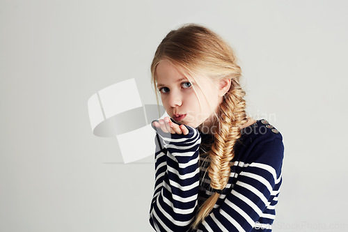 Image of Fashion, kiss and portrait of child in a studio with casual, cool and stylish outfit and hat. Happy, youth and young girl kid with positive, good and confident attitude for style by white background