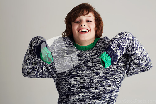 Image of Fashion, portrait and boy kid in a studio with casual, cool and stylish jersey outfit. Excited, smile and happy young child model with trendy youth style and positive attitude by gray background.