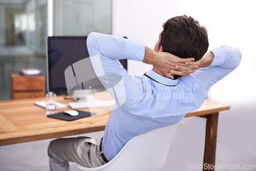 Image of Back, relax or happy man in office on break for mental health, pride or wellness at his desk or workplace. Calm, business or employee sleeping with peace or hand behind his head stretching or resting