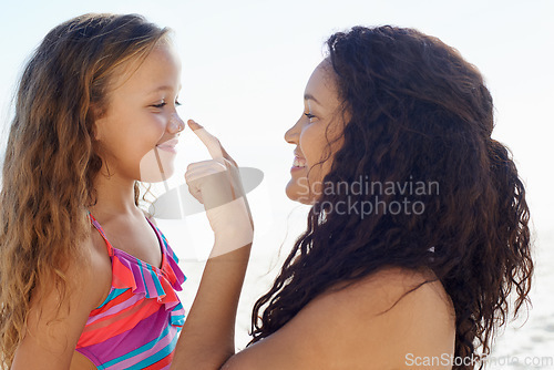 Image of Happy mother, girl and poking nose at beach for love, care or support for child or daughter in nature. Mom and cute young kid smile for touch, sense or sunscreen at ocean or outdoor sea by the coast