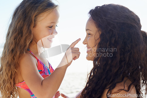 Image of Happy mother, girl and touching nose at beach for love, care or support for child or daughter in nature. Mom and cute young kid smile for poke, feel or sunscreen at ocean or outdoor sea by the coast