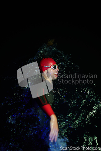 Image of Authentic triathlete swimmer having a break during hard training on night neon gel light