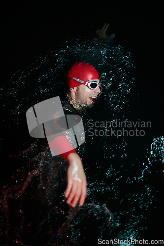 Image of Authentic triathlete swimmer having a break during hard training on night neon gel light