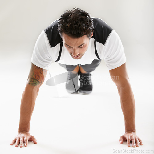 Image of Fitness, push ups or sports man training in studio for muscle or strong arms on floor in exercise. Power, white background or healthy athlete in calisthenics for wellness, energy or body workout