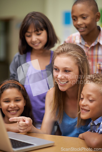 Image of Children, tutor and computer in classroom for education, learning and e learning information or group project. Happy diversity kids, students and girl with leadership on laptop at school for support