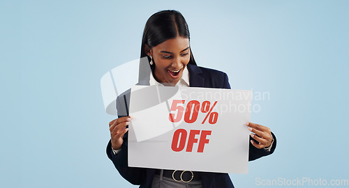 Image of woman, sale and sign for discount, advertising or deal against a blue studio background. Happy female person with billboard or poster for marketing, half price or special promotion on mockup