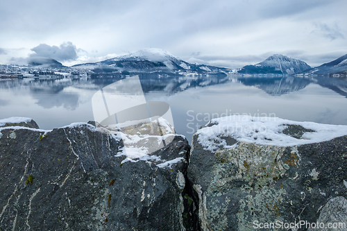 Image of Tranquil Winter Morning by the Snow-Covered Lake With Mountain R