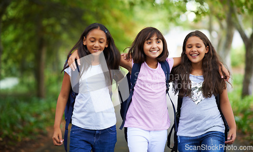 Image of Happy woman, friends and hug walking with backpack in park for unity, teamwork or school together. Group of young people or teens in nature path with bag for learning, education or outdoor class