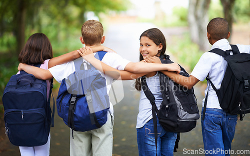 Image of Happy students, friends and hug with backpack in park for unity, teamwork or walking to school together. Rear view of young group in nature with bags for learning or education in outdoor forest