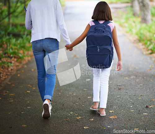 Image of Woman, teacher and walking student to school in park or outdoor forest for support or responsibility. Rear view of female person or educator holding hands with learner, kid or young child in nature