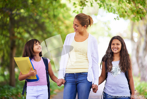 Image of Happy teacher, students and holding hands walking to school in outdoor park for support or responsibility. Woman, person or educator smile with learner, kids or young children with backpack in nature