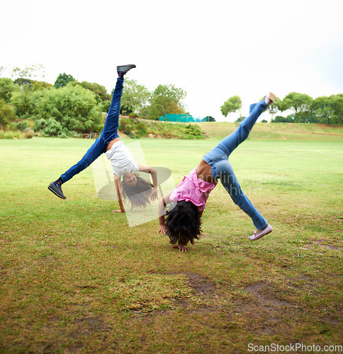 Image of Happy woman, children and friends in cartwheel on green grass or field together for fun day at the park. Young girls, teens or kids playing and handstands for freedom, activity or games in nature