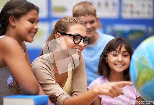 Image of Happy teacher, students and geography with planet or globe of earth in class for education or learning at school. Woman, mentor or educator smile with kids or children with world map in classroom