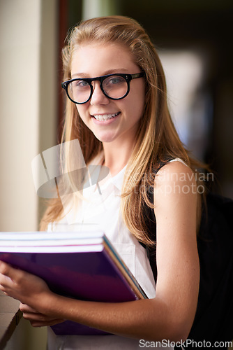 Image of Happy woman, portrait and student nerd with books at school hallway for education, study or learning. Young female person, teenager or geek smile with glasses and textbooks for knowledge in corridor