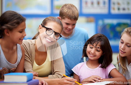 Image of Happy teacher, students and writing for learning, education or tutoring in classroom at school. Woman, mentor or educator helping young kids or children with books for studying or literature in class