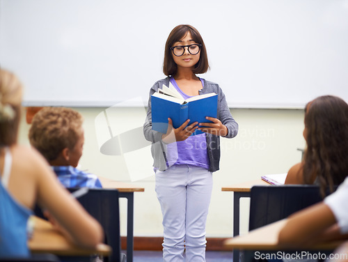 Image of Classroom, child and reading a book in presentation, information and education by whiteboard. Girl, student and learning or studying for assessment, literature and notebook for story and knowledge