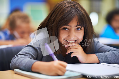 Image of Girl, education and portrait in classroom for learning, information and notes for knowledge in school. Female person, book and pride for assessment or test, studying lesson and smiling at academy