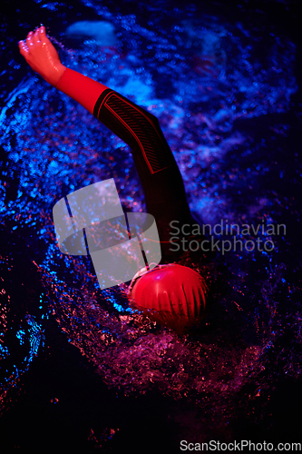 Image of Authentic triathlete swimmer having a break during hard training on night neon gel light