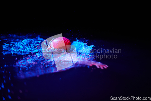 Image of Authentic triathlete swimmer having a break during hard training on night neon gel light