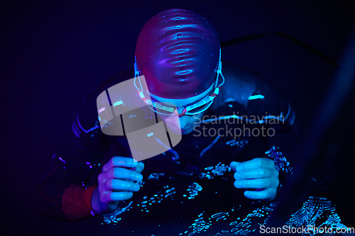 Image of authentic triathlete swimmer having a break during hard training on night neon gel light