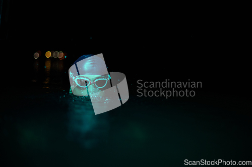 Image of Authentic triathlete swimmer having a break during hard training on night neon gel light