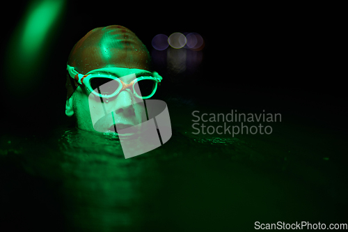 Image of Authentic triathlete swimmer having a break during hard training on night neon gel light