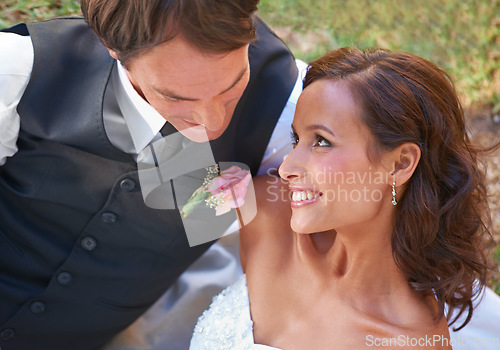 Image of Couple, romance and love on wedding day in outdoors, together and excited for marriage and commitment. Happy people, smile and union or relaxing on grass, loyalty and pride for partnership at event