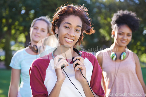 Image of College, students and portrait in the park with headphones on campus to study together with happiness and friends. University, academy and people with diversity or solidarity in education mission