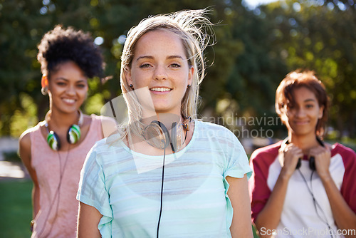 Image of College, portrait and students in the park with headphones on campus to study together with happiness and friends. University, academy and people with diversity or solidarity in education mission