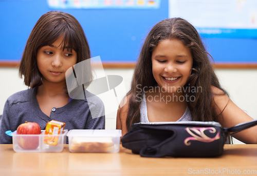 Image of Happy kids, students and eating food in classroom at school for meal, break or snack time. Young little girls or elementary children smile with lunch bag for health, nutrition or vitamins in class