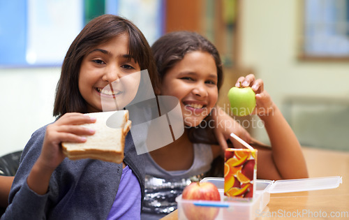 Image of Girls, happy and portrait with lunch at school for recess, break or nutrition at table with diversity. Kids, face and smile at academy or relax with confidence, food or embrace for friendship or care