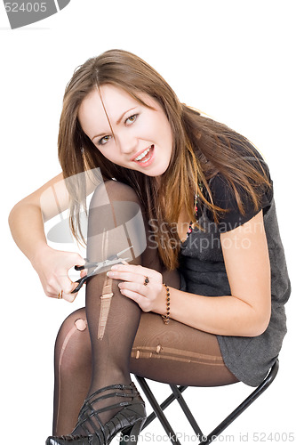 Image of Girl with scissors cuts the stockings. Isolated