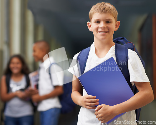 Image of Boy, portrait and happy in corridor of school with backpack and books for learning, education or knowledge. Student, person and face with smile in building or hallway before class or ready to study