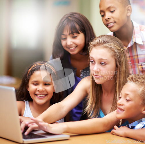 Image of Young tutor, laptop and teaching children. kids or pupils technology, social media or research in class. Group of elementary students with mentor showing tech, internet or online search in classroom