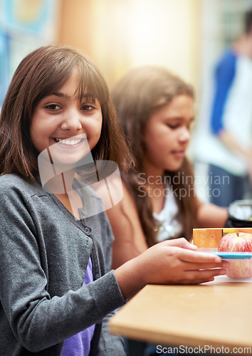 Image of Girl, happy and portrait with lunch at school for recess, break or nutrition at table with meal. Kid, face and smile at academy or relax with confidence, food or pride for childhood development